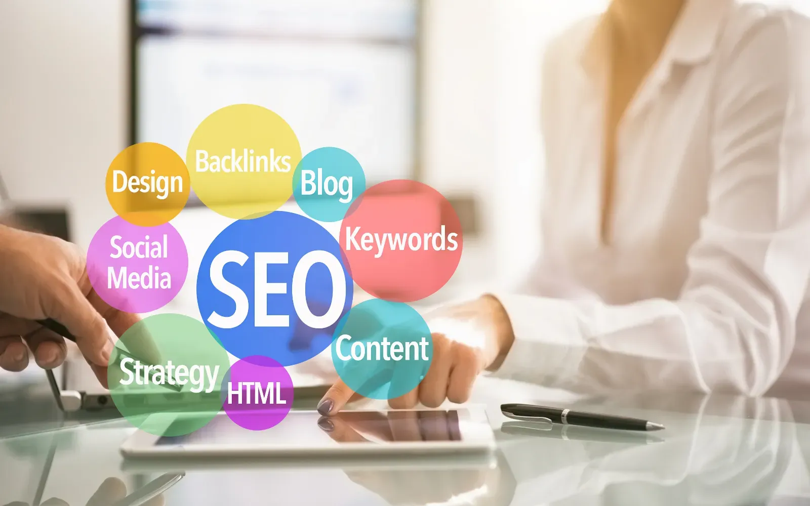 Roka pred tablico, nad njo barvni mehurčki z izrazi SEO, vsebina, blog in ključne besede